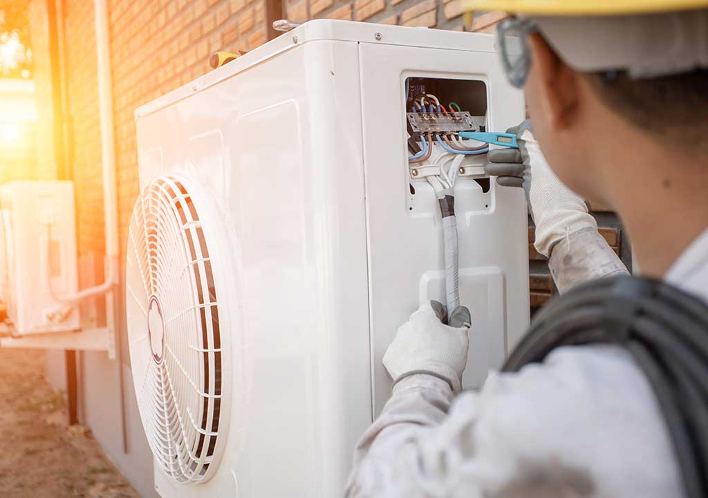 technician-looking-at-an-air-conditioner